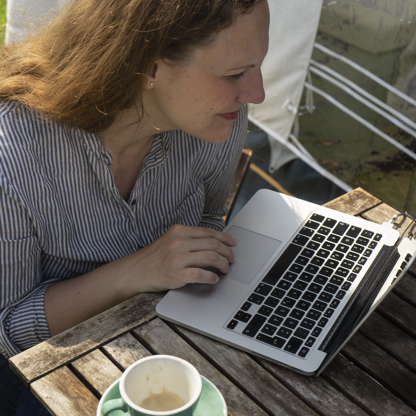 Arbeiten am Laptop an einem Tisch im Freien.
